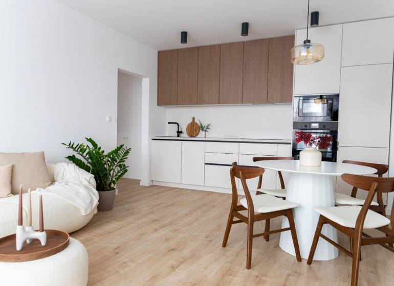 Wohnzimmer mit Küche in einer 3-Zimmer-Wohnung mit Holzboden.