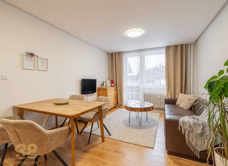Wohnzimmer in einer Ferienwohnung mit einem gemütlichen Sofa und einem Boden in Holzoptik.