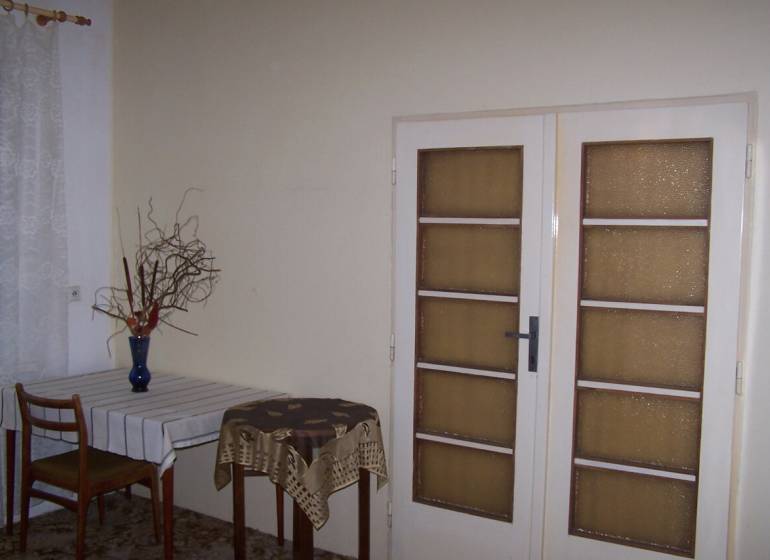 Innenraum einer 2-Zimmer-Wohnung mit Esstisch und Glastüren.