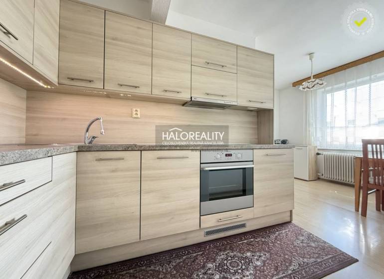 Eine Küche in einem Einfamilienhaus mit einem Boden in Holzoptik und einer modernen Küchenzeile.