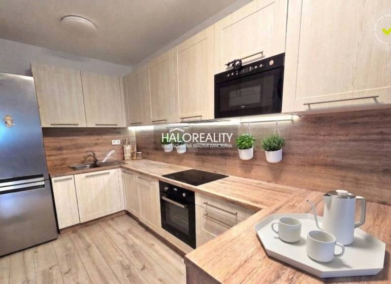 Moderne Küche in einer 2-Zimmer-Wohnung mit Holzdekor und eingebauten Geräten.