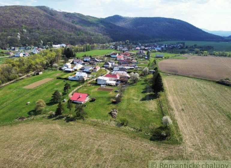 Luftaufnahme von Einfamilienhäusern in Zubné, umgeben von Feldern und Hügeln.