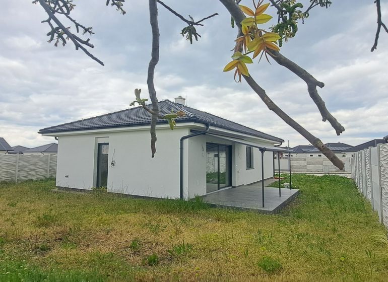 Ein Einfamilienhaus in Topoľnica mit Garten und Terrasse, umgeben von einem dekorativen Zaun.