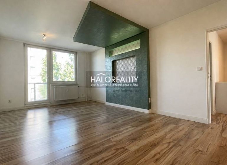 Wohnzimmer in einer 2-Zimmer-Wohnung mit Holzboden und großen Fenstern.