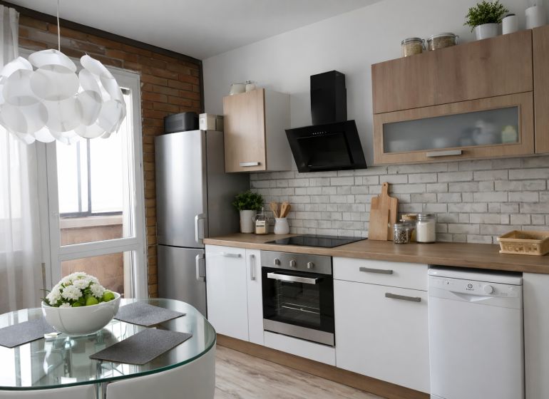 Helle Küche mit Geräten, Esstisch und Holzboden in einer 4-Zimmer-Wohnung.
