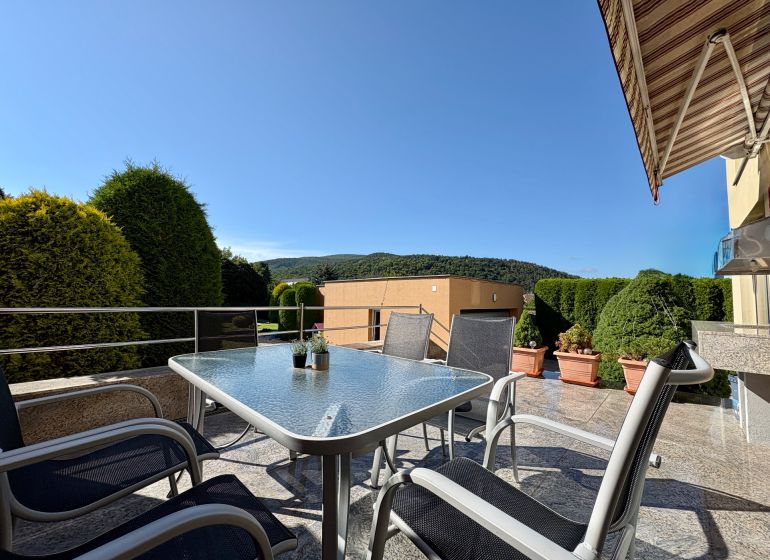 In Partizánske eine Terrasse eines Einfamilienhauses mit Gartenmöbeln und Blick ins Grüne.