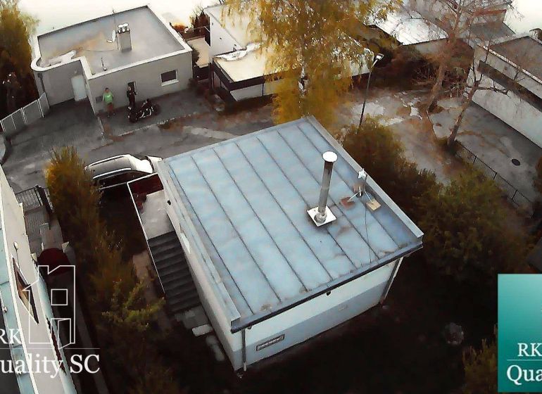 Hütte in Senec am SONNENSEE SÜD, mit Flachdach, umgebenden Bäumen und einer Straße.