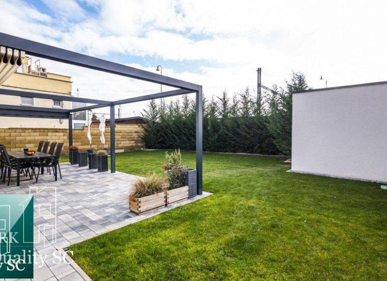 Der Garten eines Einfamilienhauses an den Sonnenseen Süd in Senec mit Terrasse und Rasen.