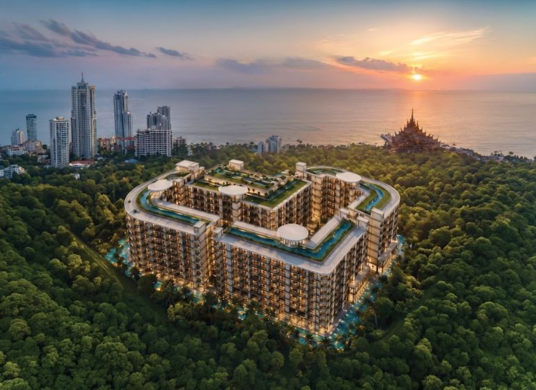 Wohnungsbau in Pattaya am Meer, umgeben von Grünflächen und hohen Gebäuden.
