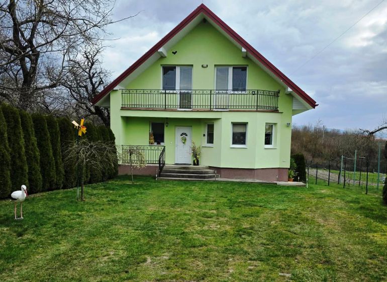 Grünes Einfamilienhaus in Klokočov mit Veranda und gepflegtem Garten.