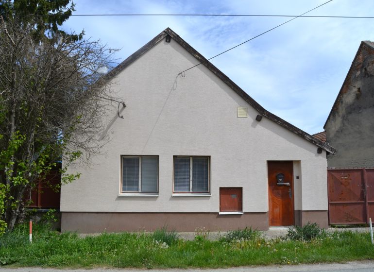 Ein Einfamilienhaus in Horné Saliby mit einer einfachen Fassade und einem Vorgarten.