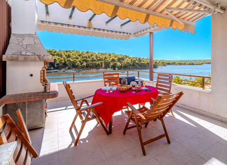 Terrasse einer Ferienwohnung in Brač mit Meerblick und Außensitzbereich.