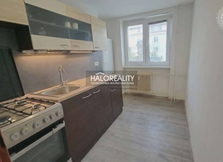 Küche in einer 3-Zimmer-Wohnung mit einem Gasherd und einem Boden in Holzoptik.