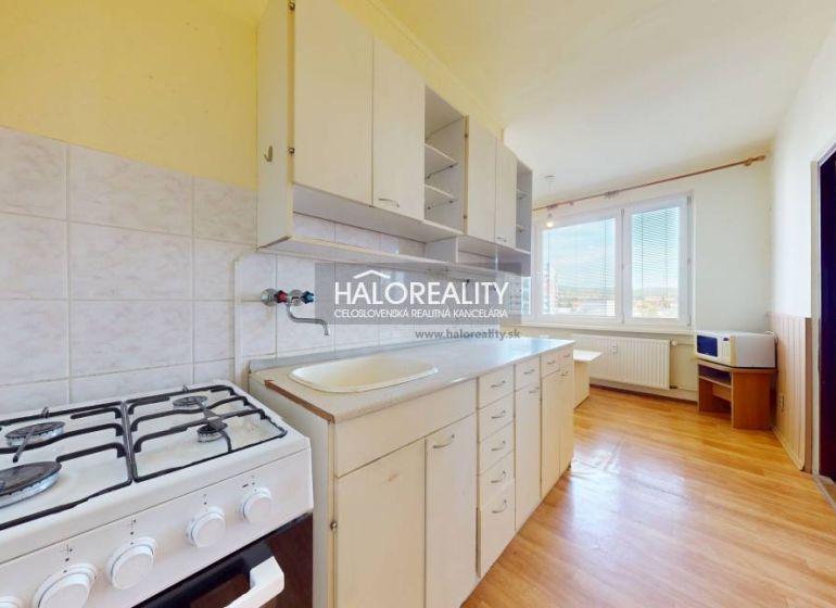 Küche in einer 2-Zimmer-Wohnung mit einem Gasherd und einem Boden in Holzoptik.