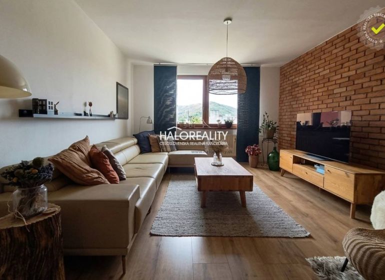 Wohnzimmer mit Ledersofa, Fernseher und Holzboden in einer 3-Zimmer-Wohnung.