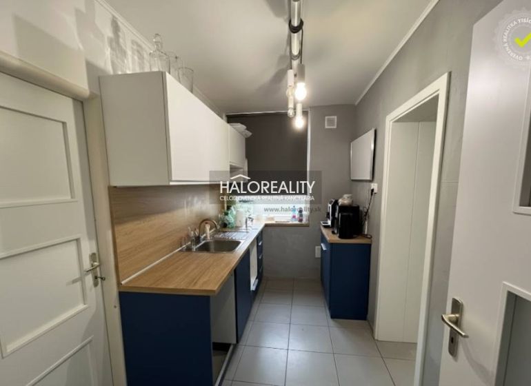 Küche in einem Einfamilienhaus mit Holzdekor-Arbeitsplatte und hellen Schränken.