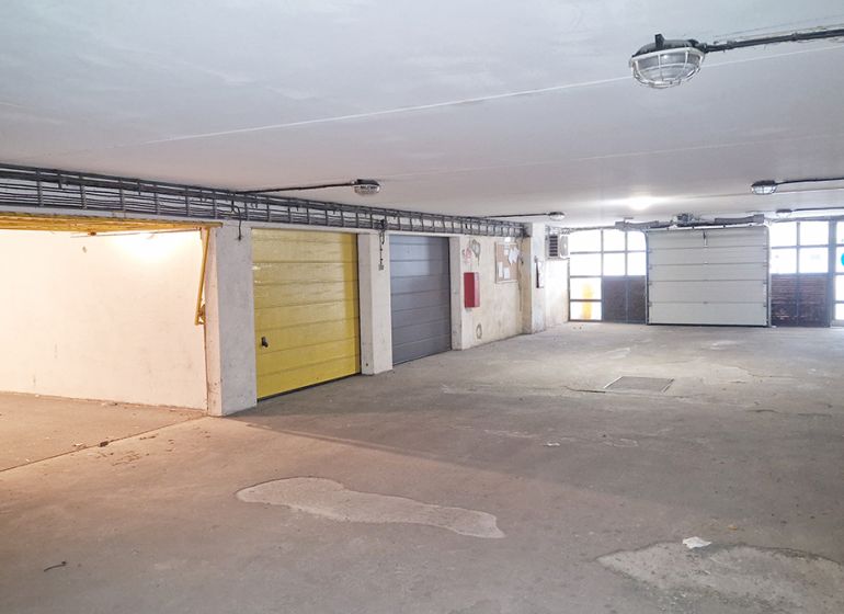 Innenraum einer Garage mit mehreren Toren, ein beleuchteter und geräumiger Raum.