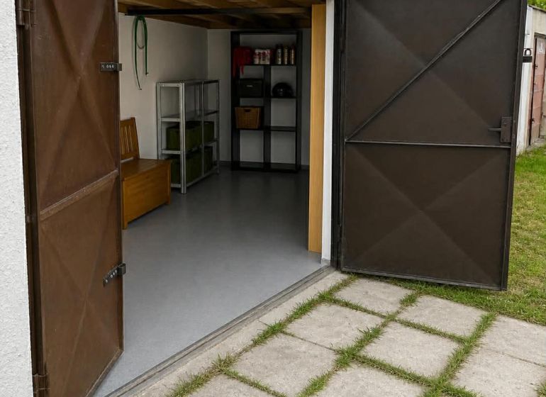 Offene Garagen in Nové Zámky mit Regalen und Betonweg.