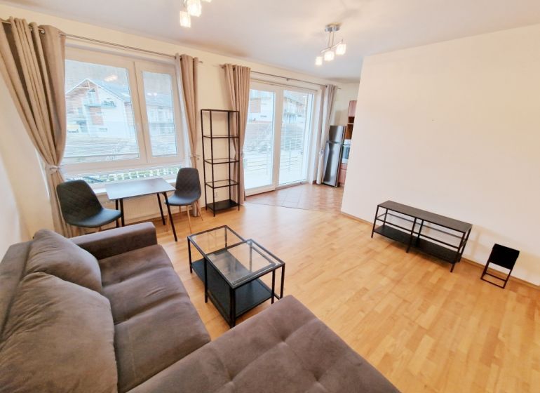 Helles Wohnzimmer mit Sofa, Tisch und Holzboden in einer 3-Zimmer-Wohnung.