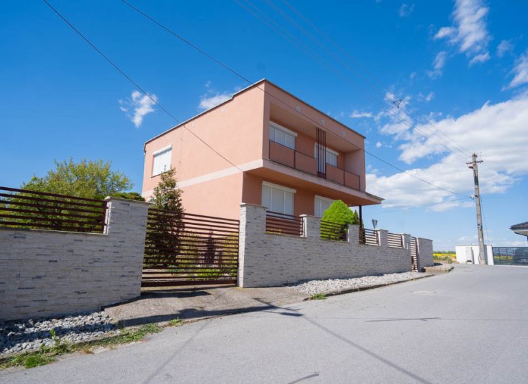 Ein Einfamilienhaus in der B. Tablica Straße in Dudince mit einer Steinmauer und blauem Himmel.