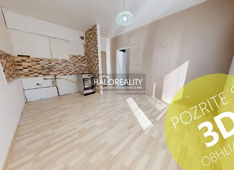 Ein Zimmer mit Holzboden und einer Kochnische in einer Einzimmerwohnung.