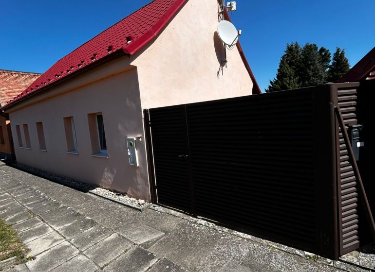 Einfamilienhaus in Mikulášov in Lakšárska Nová Ves mit rotem Dach und Satellit.