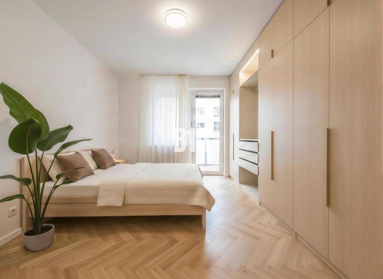 Schlafzimmer in einer 4-Zimmer-Wohnung mit einem großen Schrank und einem Boden in Holzoptik.