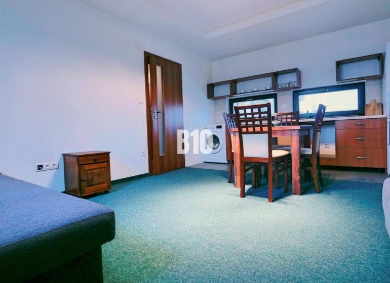 Wohnzimmer mit Sofa, Esstisch und Küchenzeile in einer 3-Zimmer-Wohnung.