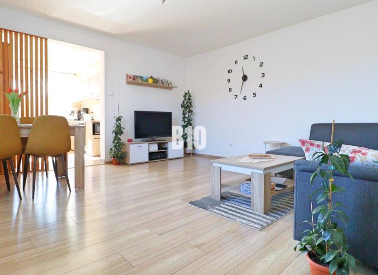 Wohnzimmer in einem Einfamilienhaus mit Holzboden, Esstisch und Sofa.