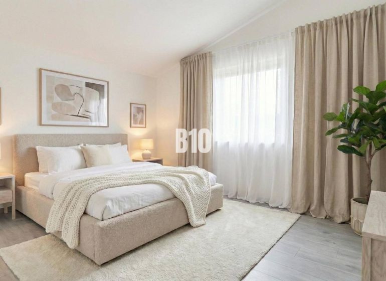 Helles Schlafzimmer mit großem Bett, Vorhängen und Pflanzen in einem Einfamilienhaus.