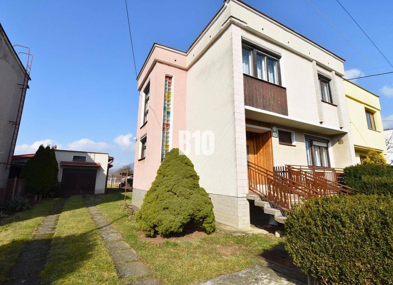 Ein Einfamilienhaus in Žilina mit Garage, Garten und Zufahrtsstraße in einem ruhigen Viertel.