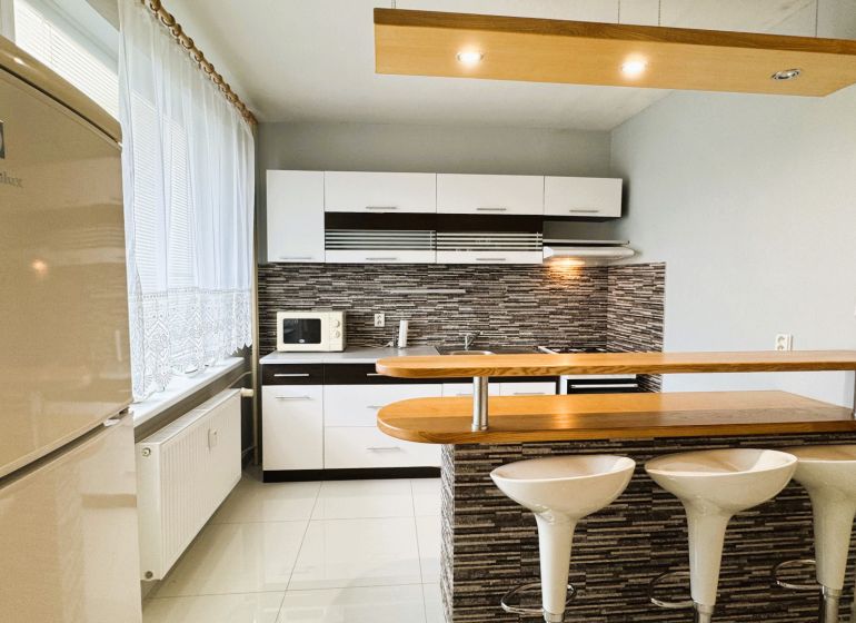 Küche in einer Einzimmerwohnung, helles Interieur, Küchenzeile, Stühle an der Bar.