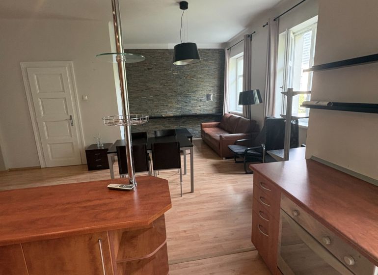 Die Küche einer 2-Zimmer-Wohnung mit einem Holzboden und einer modernen Theke.