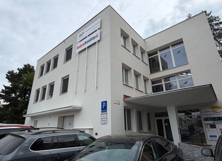 Ein Bürogebäude in der Dlhá-Straße in Prievidza mit geparkten Autos.
