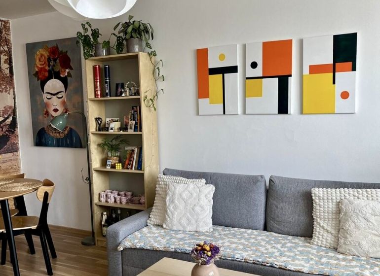 Wohnzimmer in einer 2-Zimmer-Wohnung mit Sofa, Tisch und Holzboden.