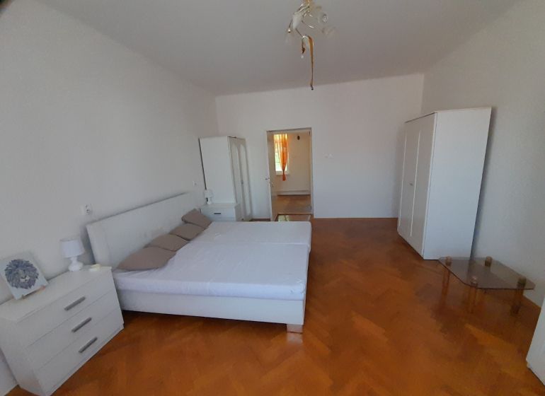 Ein Schlafzimmer in einer 4-Zimmer-Wohnung mit hellen Möbeln und einem Boden in Holzoptik.