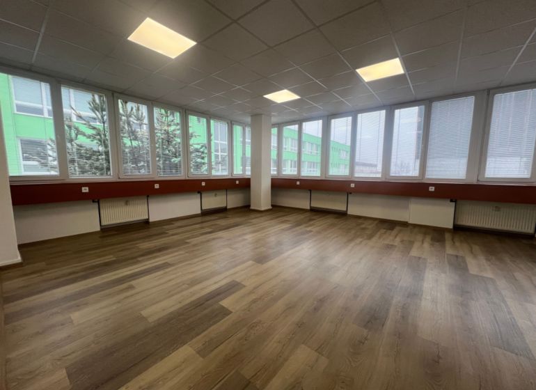 Große Büroräume mit Holzboden und großen Fenstern.