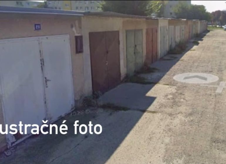 Eine Reihe von Garagen in Dunajská Streda mit unterschiedlich farbigen Türen auf einer befestigten Straße.
