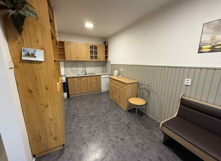 Küche in einer 4-Zimmer-Wohnung mit Holzschränken und einem Boden in Holzoptik.