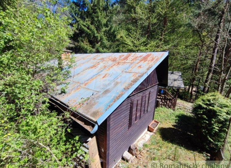 Eine Hütte im Wald bei Slovenská Ľupča, umgeben von Grün und Bäumen.