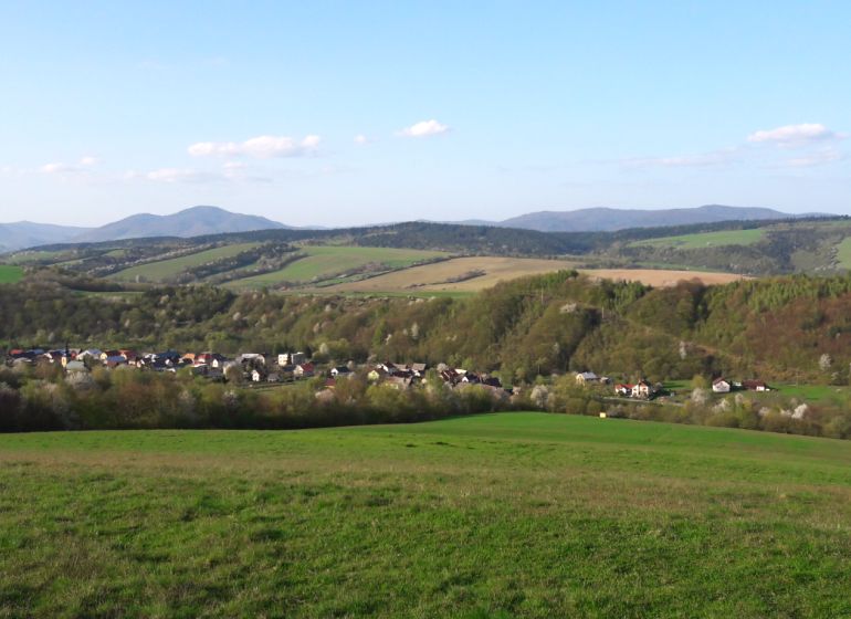 Ein Blick auf landwirtschaftliche und forstwirtschaftliche Flächen in Bogliarka mit hügeligem Horizont und Dorf.