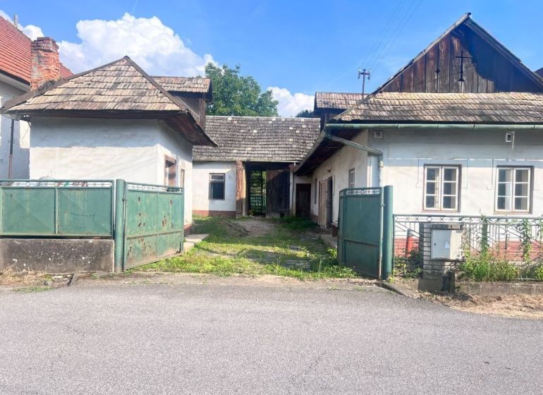 Ein Einfamilienhaus in Brechy, Nová Baňa, Bezirk Žarnovica, mit einem Blechtor und einem Schindeldach.