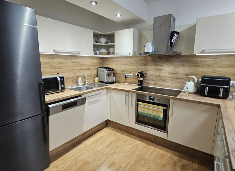 Küche in einer 3-Zimmer-Wohnung mit Holzboden und modernen Geräten.