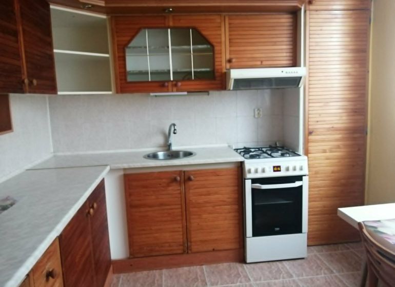 Küche in einer 3-Zimmer-Wohnung mit einer Küchenzeile in Holzdekor.