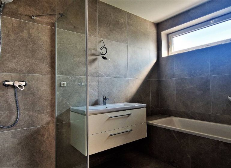 Badezimmer mit Dusche und Badewanne in einer 4-Zimmer-Wohnung.
