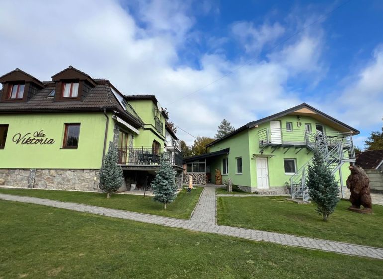 Eine Villa in Štôla, Bezirk Poprad, Region Prešov, Slowakei, mit grüner Fassade und einem sorgfältig gepflegten Garten.
