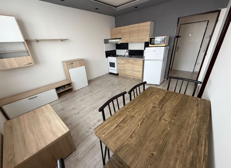 Küche und Essbereich mit Holzdekorboden in einer Einzimmerwohnung.