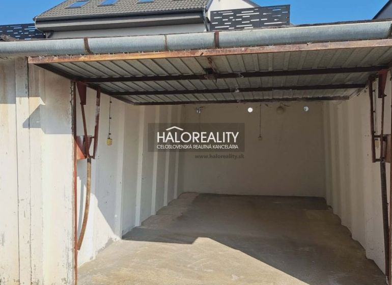 Eine leere Garage in Senec mit Überdachung und weißen Wänden.