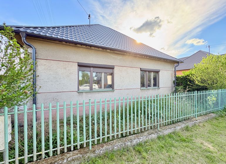 Ein Einfamilienhaus in Šoporňa mit zwei Fenstern und einem Metallzaun.