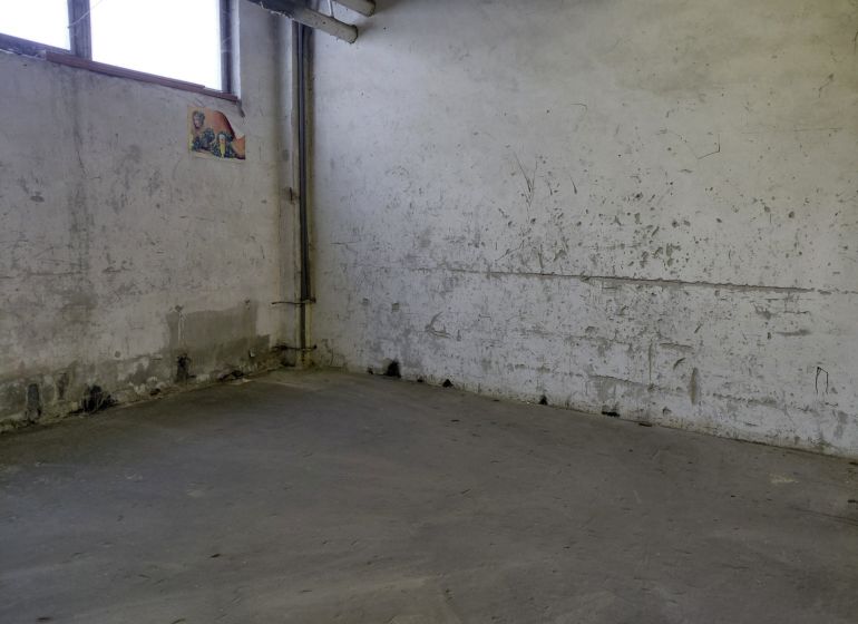 Industrielles Interieur mit abgenutzten Wänden und grauem Boden, Lager und Hallen.